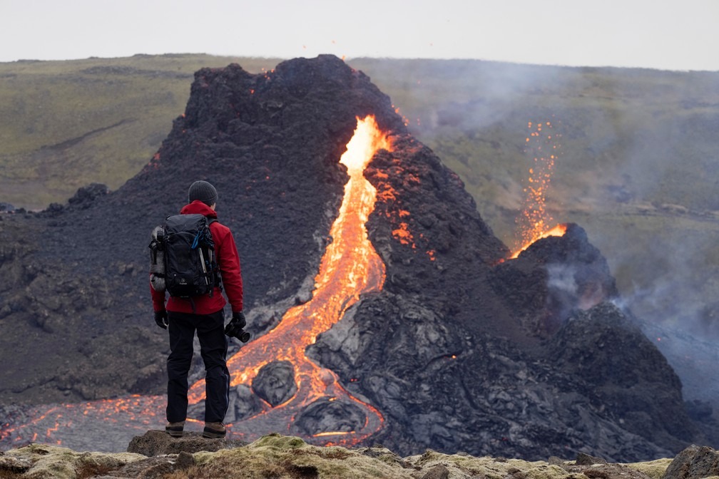 Pessoa em frente ao local do vulcão na Península de Reykjanes no domingo (21), na Islândia, após a erupção de sexta-feira (19) — Foto: Cat Gundry-Beck/Reuters