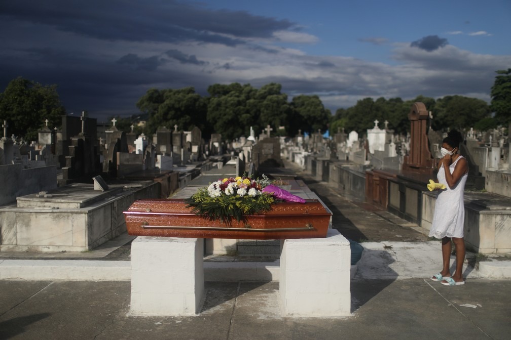 Jacira Casemiro chora, sozinha, pela mãe, Maria José Casemiro, de 79 anos, que morreu de Covid-19, durante velório no cemitério de Inhaúma, na Zona Norte do Rio de Janeiro, no dia 31 de março. — Foto: Pilar Olivares/Reuters