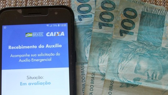 Trabalhadores podem consultar a situação do benefício pelo aplicativo do auxílio emergencial ou pelo site auxilio.caixa.gov.br. Foto: Divulgação G1.