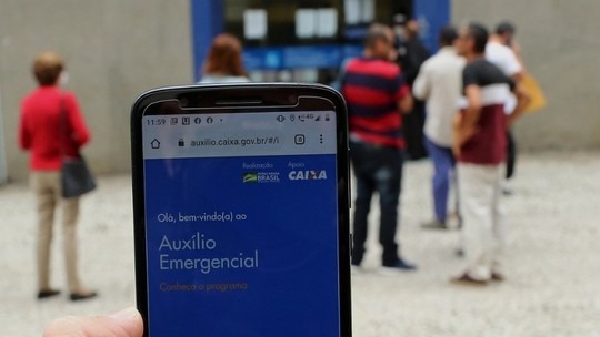 Os trabalhadores podem consultar a situação do benefício pelo aplicativo do auxílio emergencial ou pelo site auxilio.caixa.gov.br. Foto: Divulgação G1.